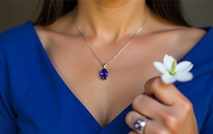 A hand raised in the air holding a freshly mined natural tanzanite stone.