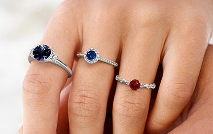 A woman wearing multiple spinel rings on her hand.