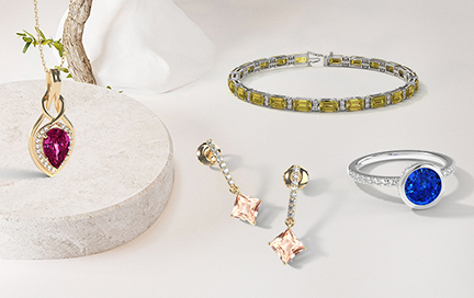 A woman casually working or sipping coffee while wearing a sapphire bracelet or studs