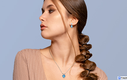 A woman wearing Paraiba tourmaline earrings and a matching pendant.