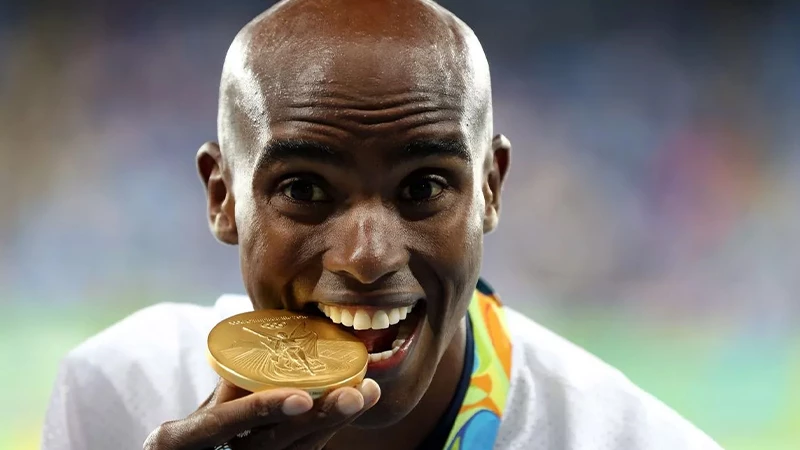 athlete biting the Olympic medal