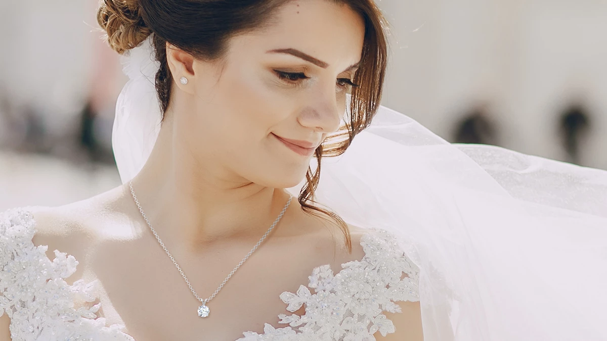 bride wearing her wedding gown and diamond pendant & earrings