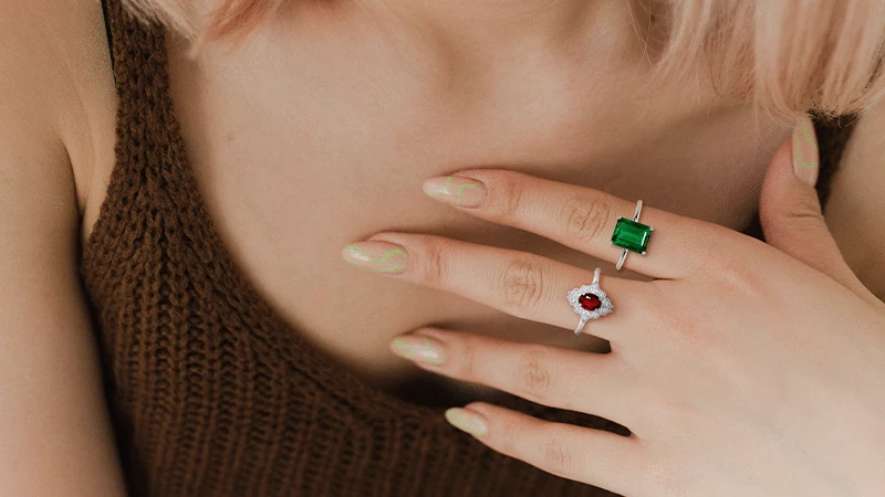 wearing ruby and emerald rings