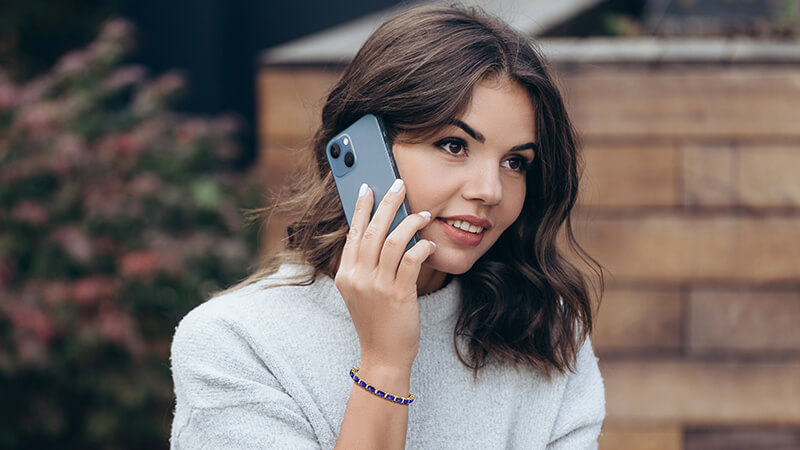 woman holding an iPhone wearing a tanzanite bracelet