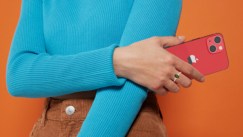 woman holding a red iPhone wearing an alexandrite ring 