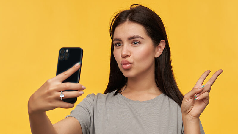 woman holding a black iPhone wearing a tapered cathedral diamond ring