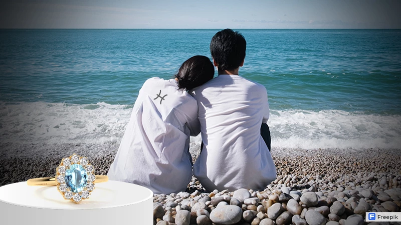 couple sitting on the rocks looking at the sea